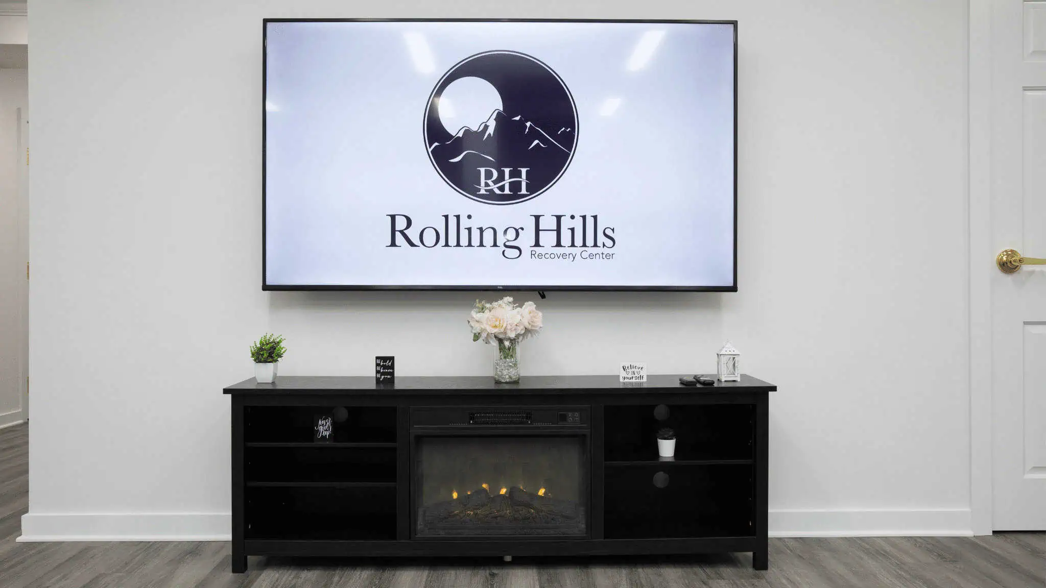T.V. mounted on the wall with the Rolling Hills logo on it.