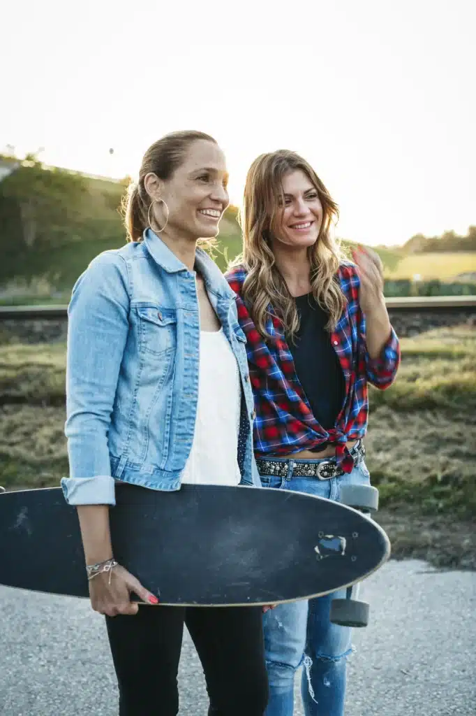 Two smiling friends with longboard