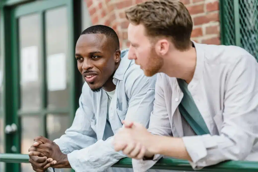 Two men talking on a balcony about opioid addiction treatment in New Jersey.