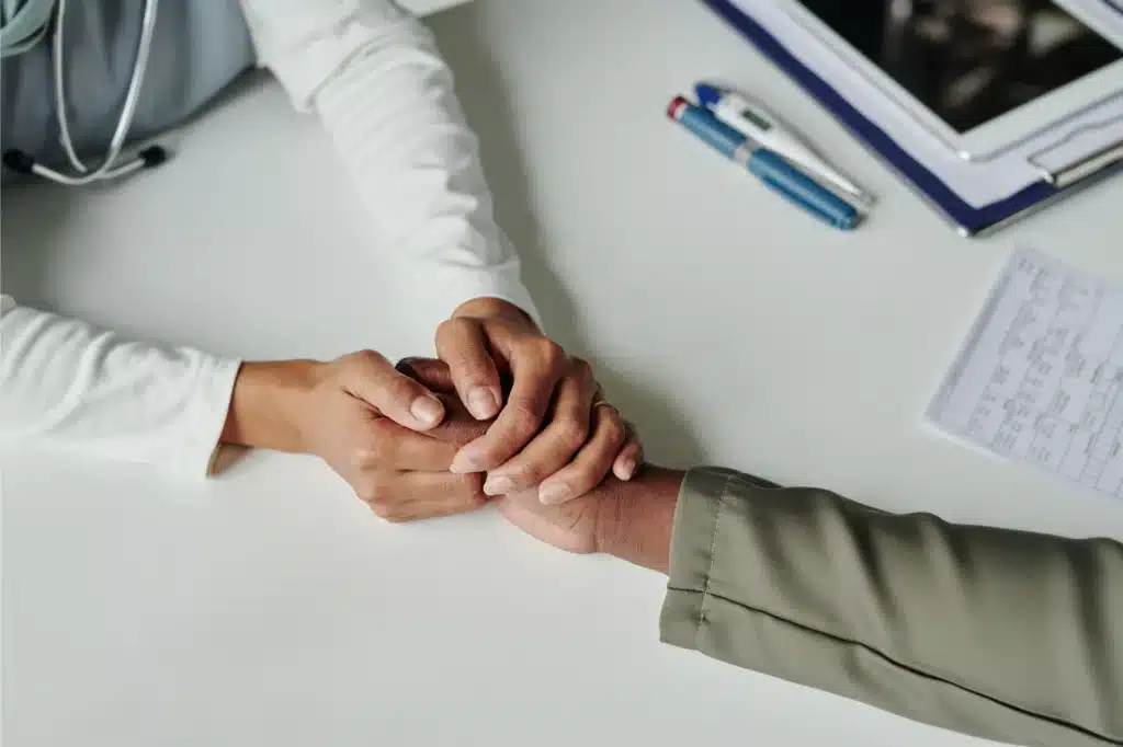 Two hands holding in support