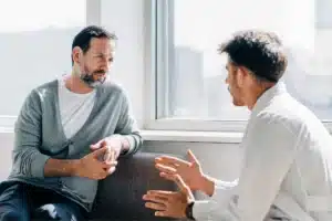 Therapist providing drug abuse counseling to a patient during one-on-one recovery session.