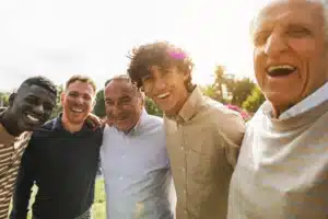 Smiling group of men outdoors representing peer support and community in rehab