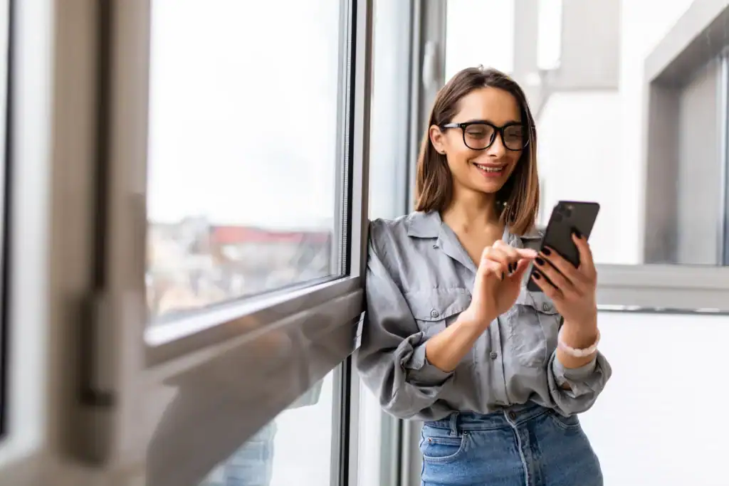 Woman using a smartphone to look up when a 90 day rehab program may be recommended.
