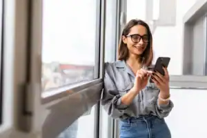 Woman using a smartphone to look up when a 90 day rehab program may be recommended.